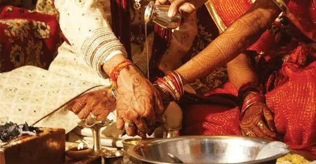 Hands with mehendi during the kanyadaan step of a Vedic vivah vidhi