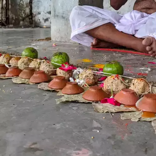 Pind daan with rice pinds and clay diyas on leaves during Narayan Bali vidhi