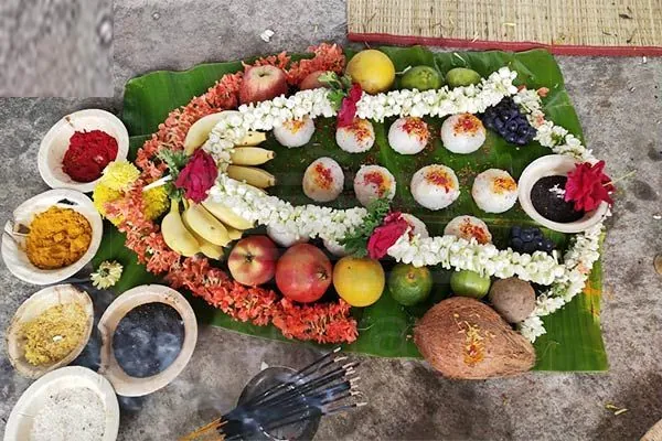 Narayan Nagbali puja samagri on banana leaf with pinds, flowers, fruits, coconut, haldi and kumkum